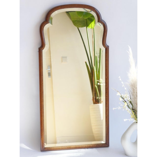 A tall antique wooden scalloped mirror made in the Netherlands. The wall mirror has a beautiful curved wooden frame made...
