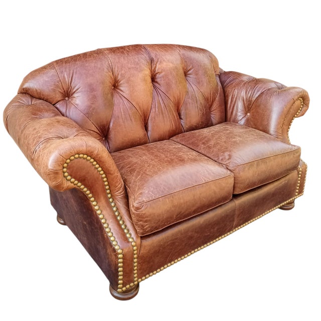 Elevate your living space with the timeless elegance of this Thomasville Chesterfield leather sofa and matching ottoman....