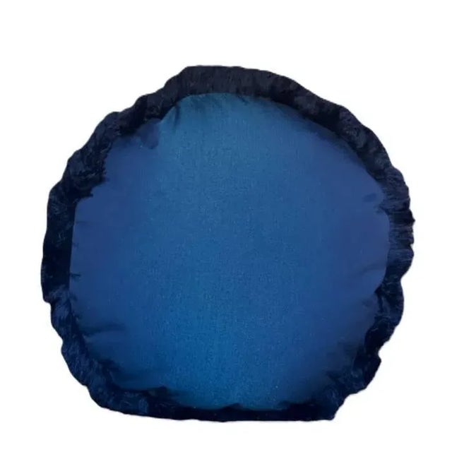 Round outdoor pillow made with a high performance fabric in a shimmering deep blue shade. Trimmed with a brush fringe in...