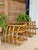 A fabulous pair of true vintage bent rattan side tables featuring sculptural curved frames, woven lower shelves, and their...