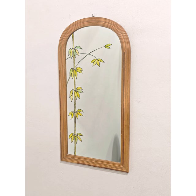 This is an arched mirror with a bamboo and wicker frame, likely dating to the 1960s or 1970s. Its distinctive feature is...