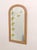 This is an arched mirror with a bamboo and wicker frame, likely dating to the 1960s or 1970s. Its distinctive feature is...