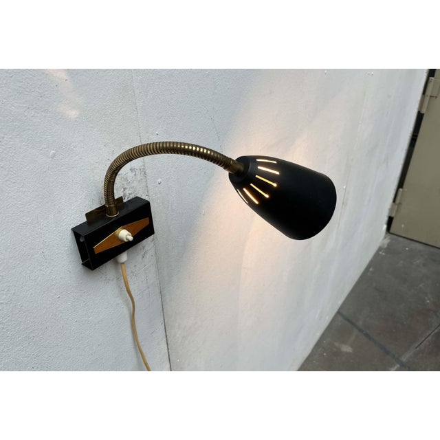 Mid-Century Modern gooseneck lamp by the Finnish manufacturer Aris from the 1950s. A classic design in black and brass....