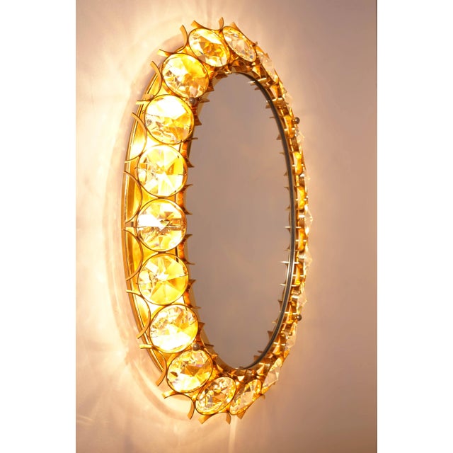 This large oval mirror was manufactured by Palwa in Germany. The mirror is held by a gold-plated brass frame and...