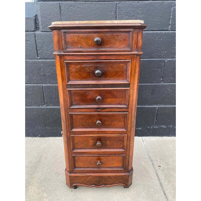 An exquisite 19th-century French walnut nightstand showcasing exceptional marquetry craftsmanship, elegant proportions,...