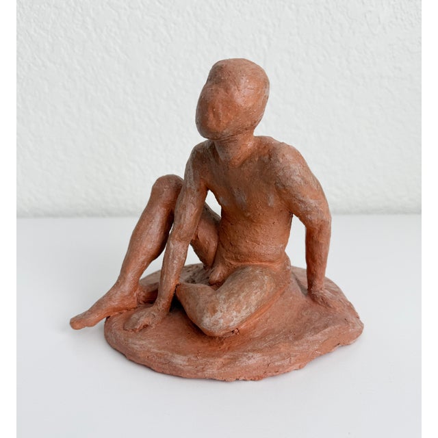 1950s sculpture of a seated male figure, handmade with red clay. Artist signed