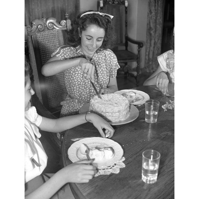 Elizabeth Taylor At Home LOS ANGELES - CIRCA 1947: Actress ElizabethTaylor helps at the dinner table at home circa 1947 in...