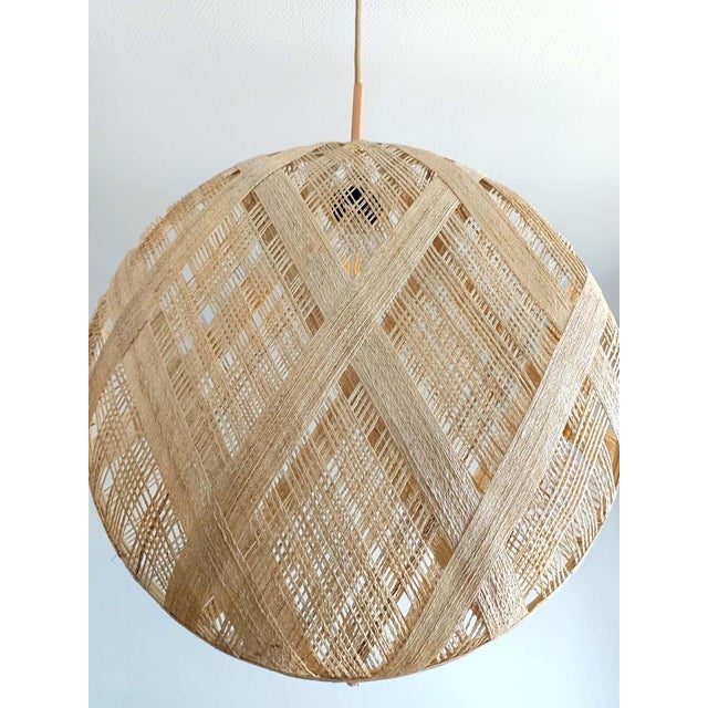 Large round pendant light composed of two woven abaca discs in a style reminiscent of openwork basketry. Textile cord and...