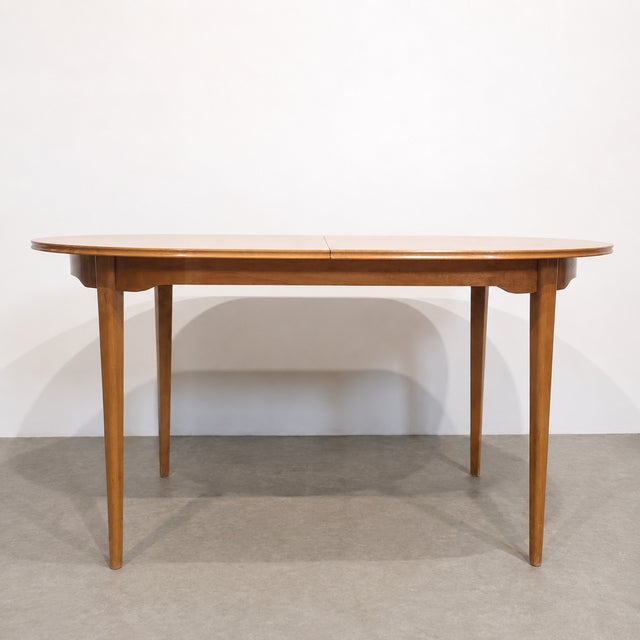 Elegant vintage Imexcotra extendable dining table from the 1960s. The table features a softly shaped oval top with a warm...