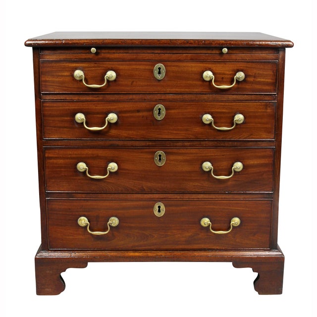 With rectangular top over a brushing slide over four graduated drawers raised on bracket feet.