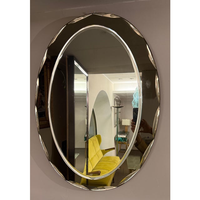 Italian oval shaped mirror in the style of Fontana Arte. The mirror is in bronze colored glass. Very good vintage...