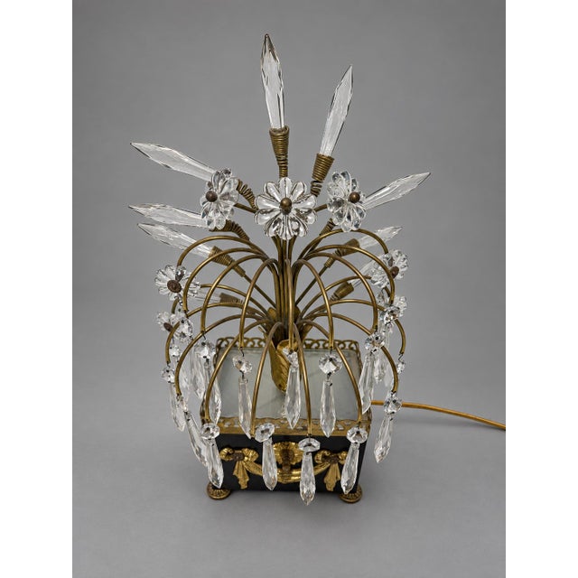 A decorative table lamp attributed to Maison Jansen, probably mid-20th century, combining brass and gold-finished metal...