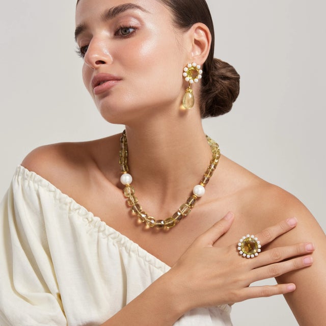 The Clementine Ring features a stunning circular semi-precious stone surrounded by an array of contrasting stones, exuding...