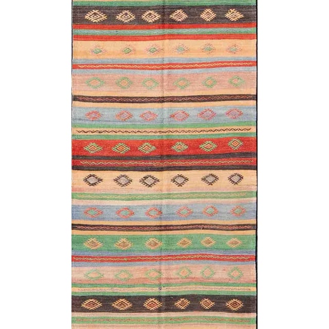 Featuring tribal shapes with a spotted and speckled assortment of geometric elements, rendered in a repeating stripe...