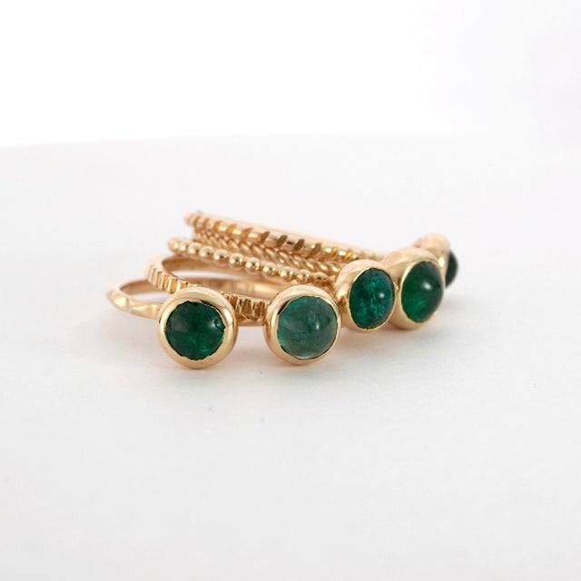 ALL FIVE RINGS SOLD TOGETHER Symbolic of Elegance and Grace. Set with Cabochon-Cut Emeralds Accented by Smooth Bands of...