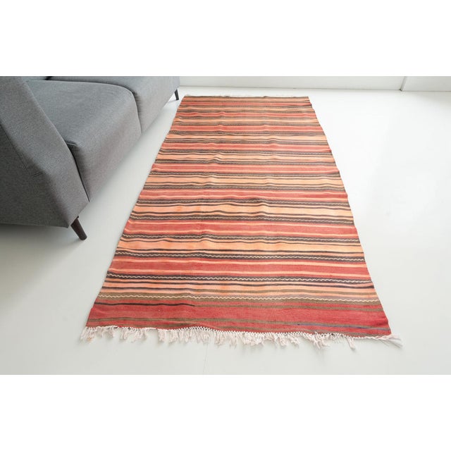 This is a vintage Turkish Oushak rug from the Mid 20th Century. The piece was hand-knotted.