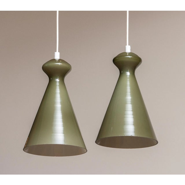 Beautiful olive green glass pendant designed in the 50's by Maria Lindeman for Idman Oy in Finland. Both shades are in...