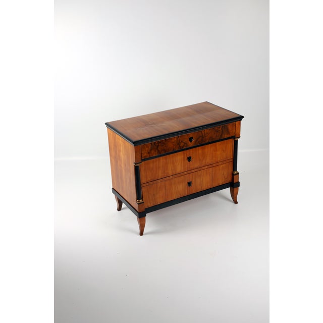 I am offering an elegant, original cherrywood veneered chest of drawers with a beautiful grain, ebonized top edge, three...