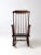 An antique American Windsor rocking chair distinguished by slender spindles, elegantly shaped arms, and a balanced,...