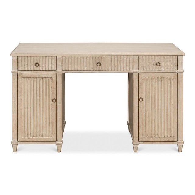 Repeated vertical grooves give the writing desk its restrained rhythm. Vertical reeding runs the length of every drawer...