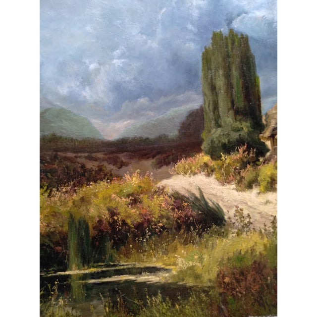 A romanticized European pastoral landscape featuring a rustic, half-timbered thatched-roof barn or cottage alongside tall...