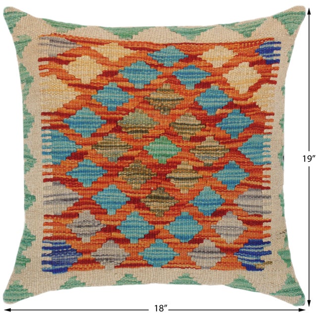 A lattice of small orange and blue diamonds covers a cream ground with teal trim. The all-over pattern adds texture and...
