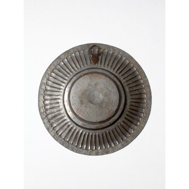 Vintage embossed tinned copper wall plate with fluted rim, geometric repoussé detailing, and central elephant medallion....