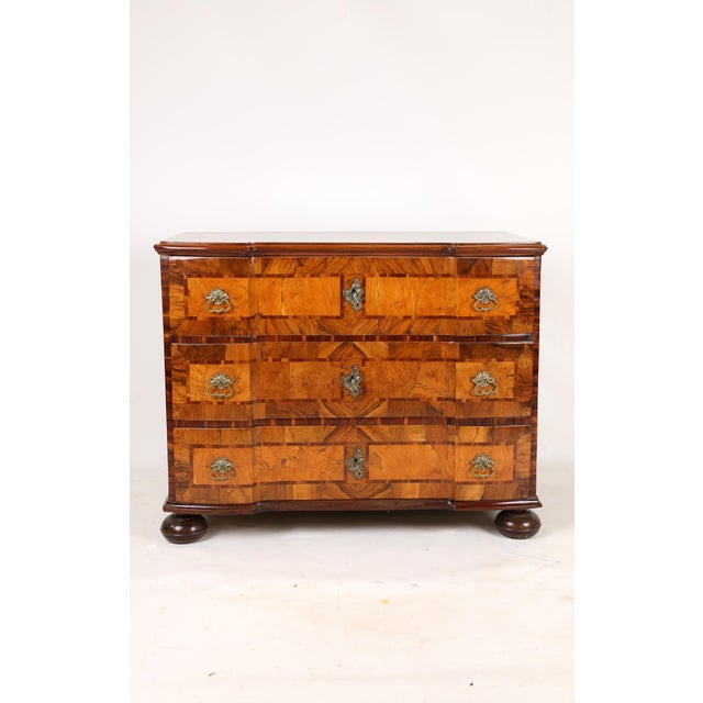 A very elegant original chest of drawers with a beautifully inlaid top, beneath which are three double-curved drawers with...