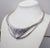 1980s Deco style rhodium plated openwork ridged v shape front collar necklace with fold over clasp and extender. Marked...