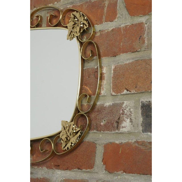 Oval mirror from the 50s and 60s; brass structure with scrolls and foliage, all in excellent condition.