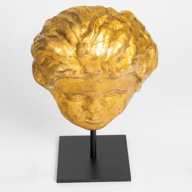 A gilded wooden sculpture of a cherub’s head from the 17th or 18th century. A sculpture of an angel’s head in the italian...