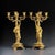 An exceptional pair of French Empire Revival gilt bronze figural candelabra, masterfully sculpted as elegant classical...