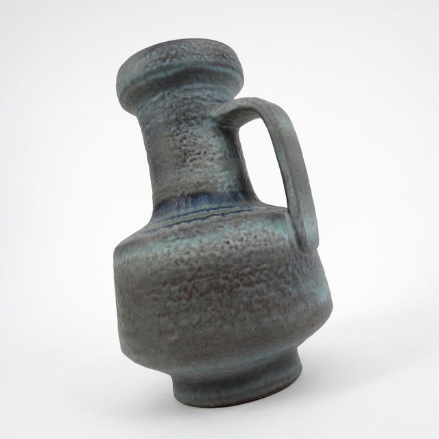 This ceramic vase follow a brutalist design combing different tones of blue and grey.