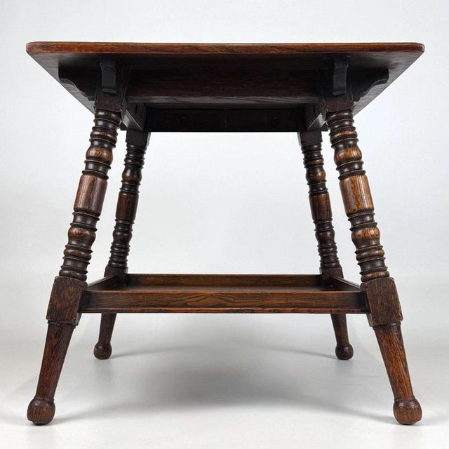 A handsome early 20th-century English side table, finely crafted from oak and distinguished by its elegant turned legs,...