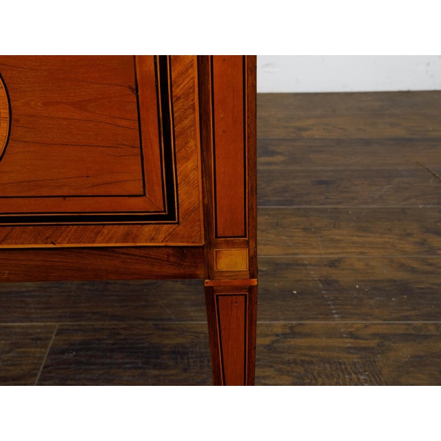 A pair of Italian Neoclassical style walnut bedside tables from circa 1800 with two drawers and marquetry décor. This pair...