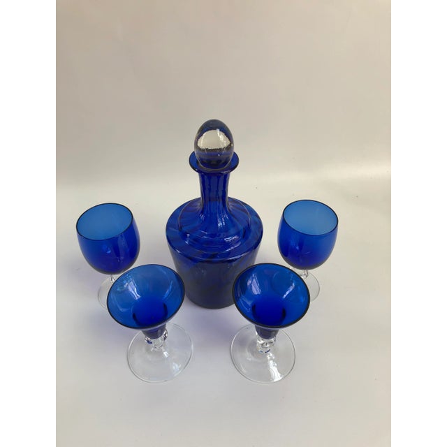 Vintage cobalt blue decanter with removable stopper and four mismatched stems. Decanter, 4.75" Dia x 9.45" H; trumpet...