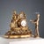 Gilded antimony clock with a wide base decorated with leafy scrolls. Enamelled metal dial with Roman numerals surmounted...