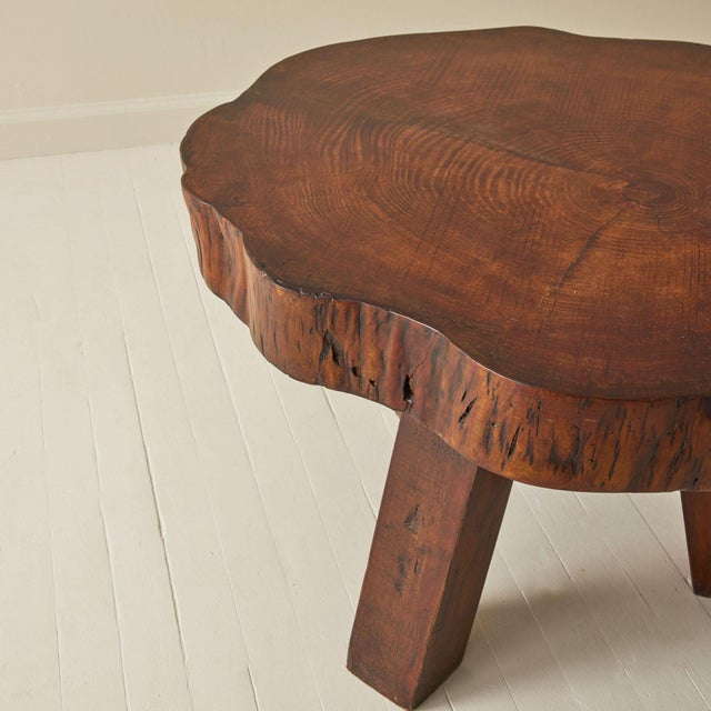Solid wood table made with a cross section of a tree trunk, 1950's. Shows the gorgeous natural grain of the wood, which is...