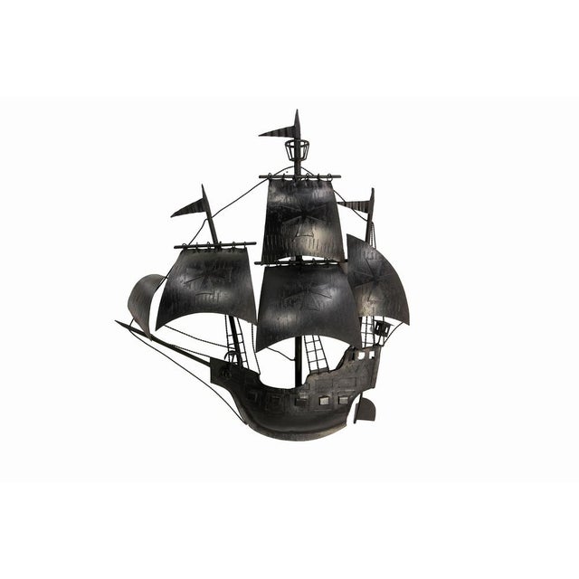 A large french decorative wall sconce depicting an antique multi-masted sailing ship, crafted entirely from worked metal...