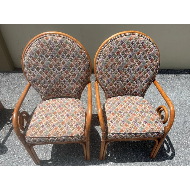 A set of four Midcentury bamboo frame dining chairs cushion upholstery that has a multicolored design.