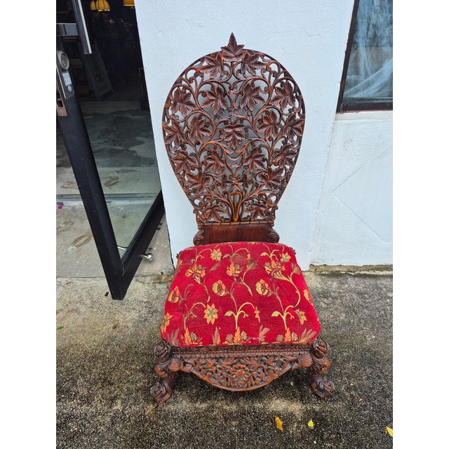 Rare and unusual 19th century Anglo Indian low chair handcrafted in mahogany featuring a floral carved back, button tufted...