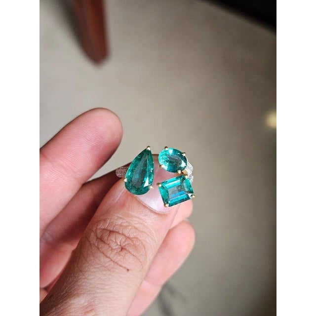 A very gorgeous and beautiful, Emerald three Stone Ring set in 18K Matte Yellow Gold & Diamonds. The weight of the...