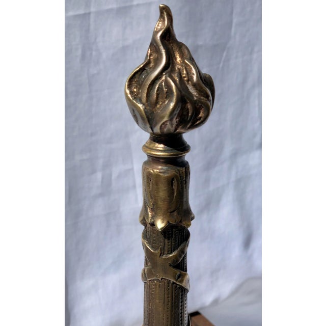 A Pair French Andirons. Item features brass fluted columns, flame finials, clawfeet, and cast iron supports. Mid 20th...