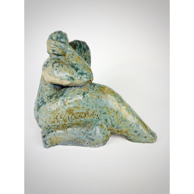 A striking one-of-a-kind hand-built studio ceramic sculpture depicting a reclining female figure in an expressive...
