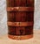 A characterful late 19th-century French wine bottle constructed from warm golden oak and bound with contrasting copper...