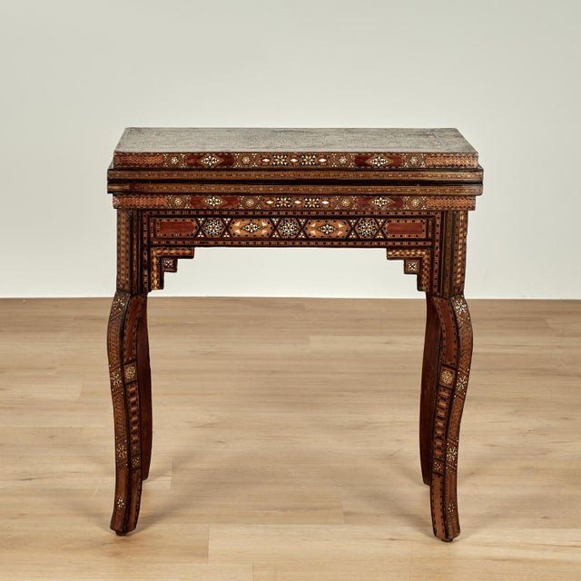 Lofty refined antique Moroccan game table with multiple uses, crafted in walnut having elaborate inlaid geometric...