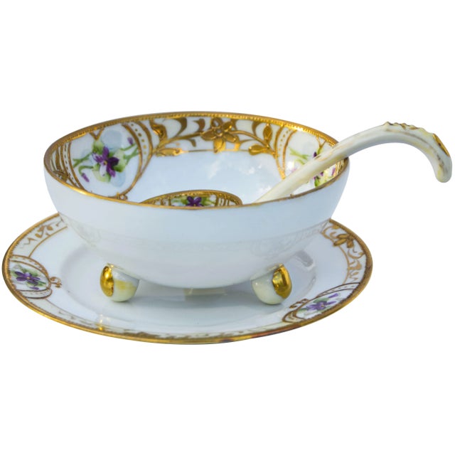 Vintage hand-painted porcelain set consisting of footed bowl, saucer and spoon. Featuring a colorful floral design with...