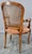 A caned back accents the back of this fauteuil from the 19th century in France. The seat has been covered in suede which...
