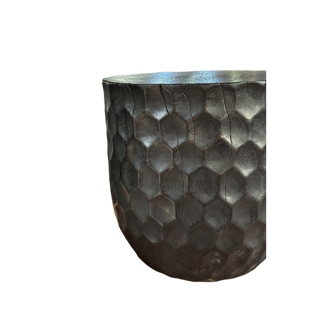 Crafted from solid mango wood, this sculptural side table is distinguished by its richly textured surface, featuring an...