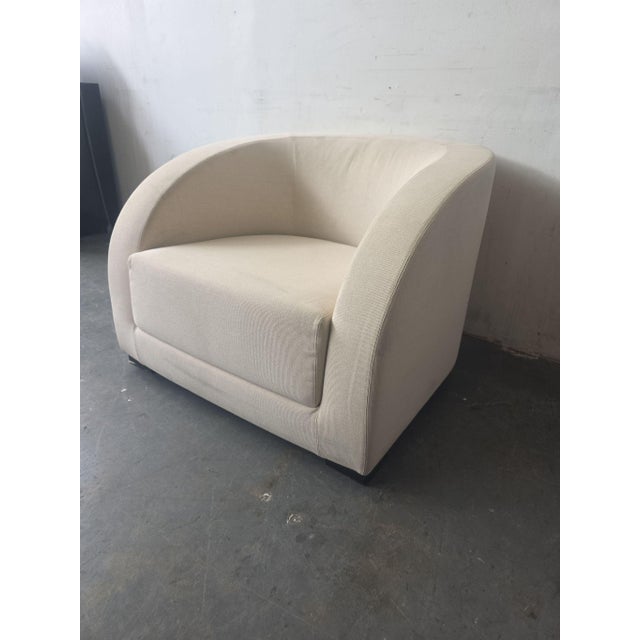 This Armani Casa lounge chair features a soft beige fabric and a sleek, modern design. Its curved back and wide seat offer...